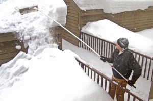 man using snow rake