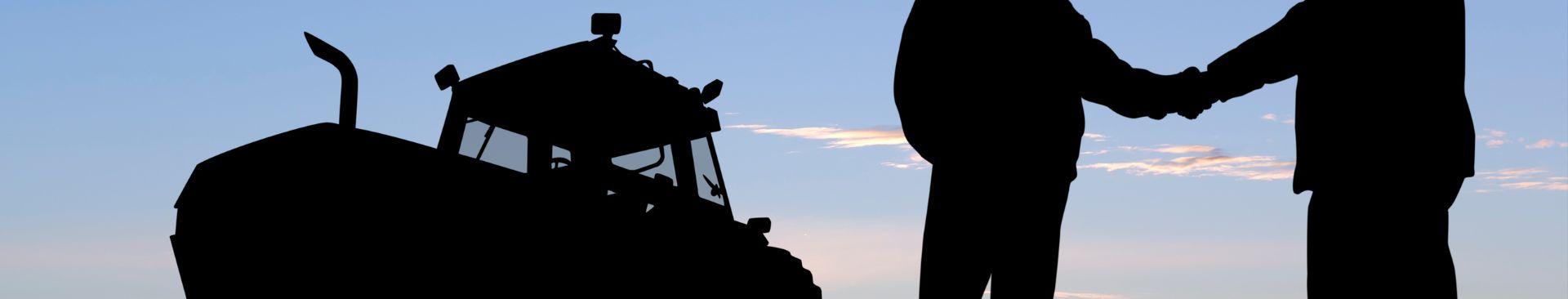 farmers shaking hands by tractor