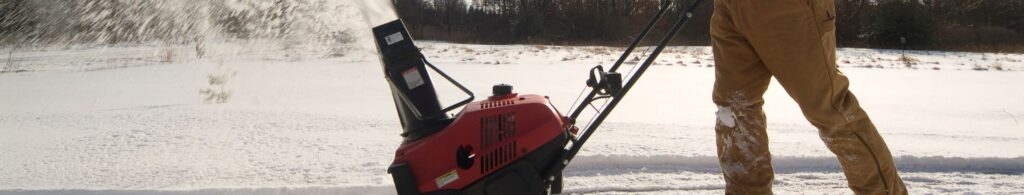 man snow blowing driveway