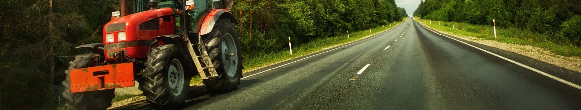 tractor driving on side of the road