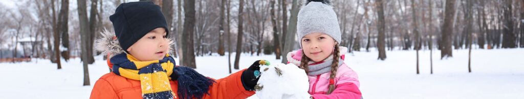 boy and girl building snowman