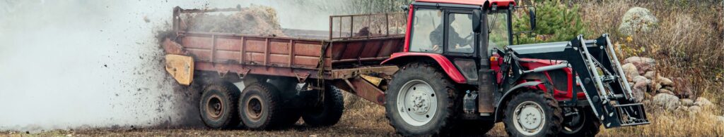 tractor spreading manure in farm field